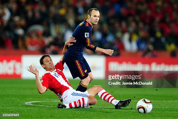 Andres Iniesta of Spain is tackled by Jonathan Santana of Paraguay during the 2010 FIFA World Cup South Africa Quarter Final match between Paraguay...