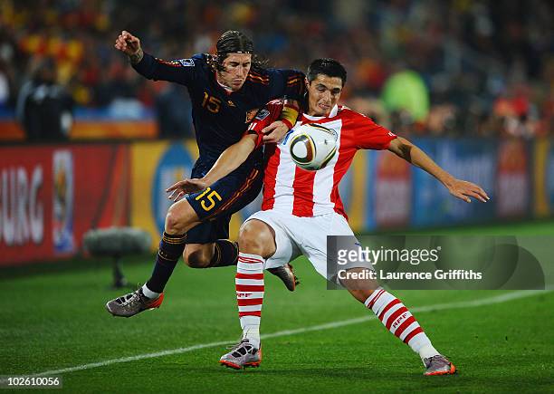 Sergio Ramos of Spain and Oscar Cardozo of Paraguay battle for the ball during the 2010 FIFA World Cup South Africa Quarter Final match between...