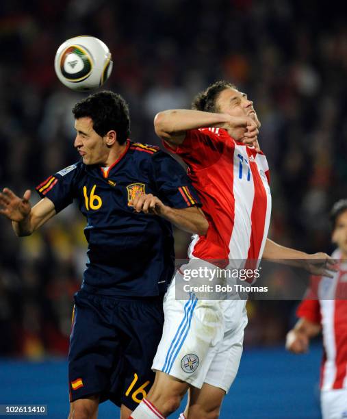 Sergio Busquets of Spains heads the ball with Jonathan Santana of Paraguay during the 2010 FIFA World Cup South Africa Quarter Final match between...