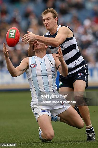 Ben Warren of the Kangaroos attempts to mark as Darren Milburn of the Cats spoils during the round 14 AFL match between the Geelong Cats and the...