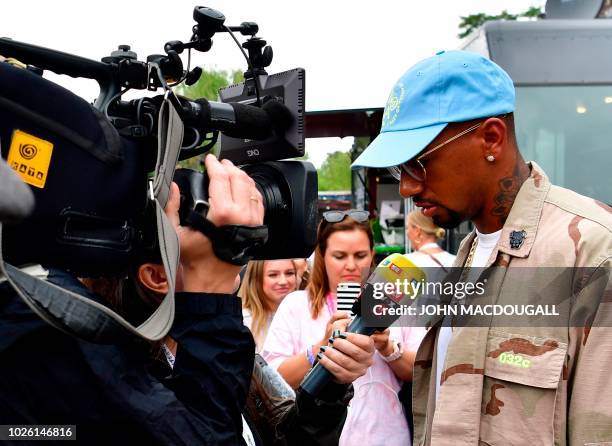 Bayern Munich's German defender Jerome Boateng speaks to reporters as he visits the Bread and Butter B&B fashion fair on September 2, 2018 in Berlin....