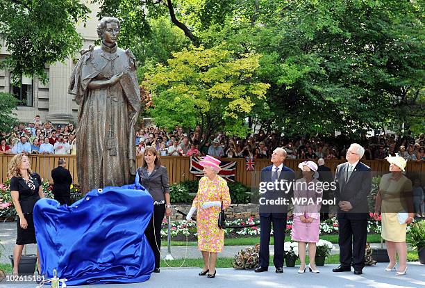 Queen Elizabeth II , beside Prince Philip, Duke of Edinburgh, unveils a statue of herself in the garden of Government House on July 3, 2010 in...