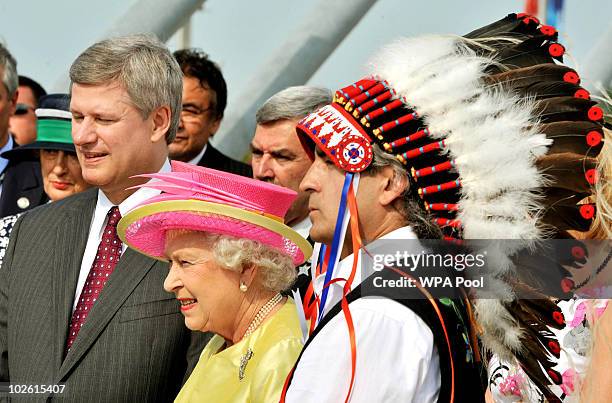 Queen Elizabeth II stands between Canadian Prime Minister Stephen Harper and Indian Chief Donovan Craig Fortune, after crossing a bridge on July 3,...