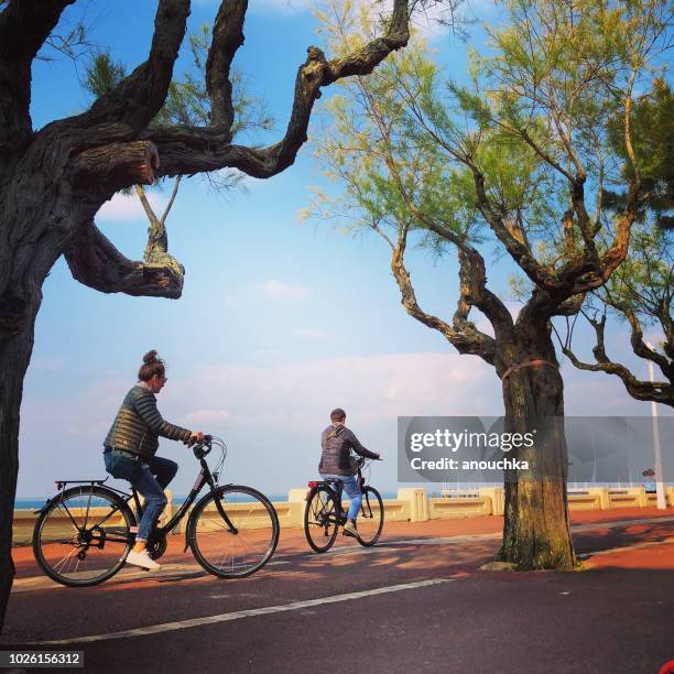 menschen, die radfahren entlang des strandes, arcachon, frankreich - arcachon stock-fotos und bilder