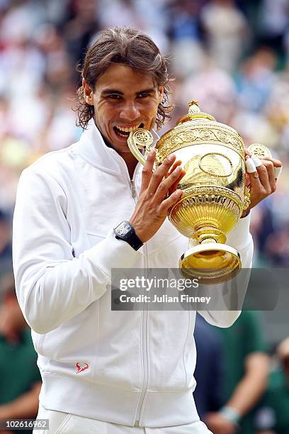 Rafael Nadal of Spain bites the Championship trophy after winning the Men's Singles Final match against Tomas Berdych of Czech Republic on Day...