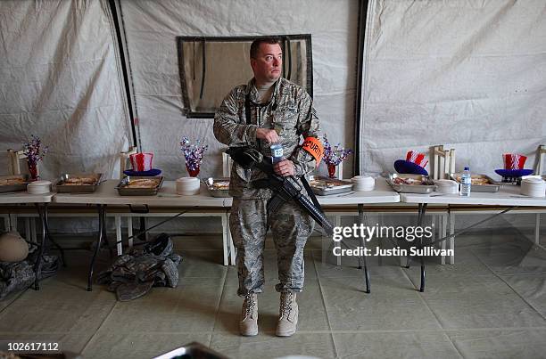 Air Force Staff Sgt. Timothy Secora guards a table with desserts during an Independence Day BBQ for troops at Kandahar Airfield July 4, 2010 in...
