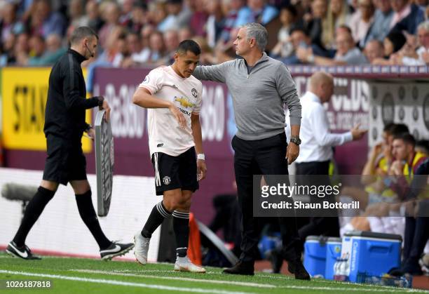 Alexis Sanchez of Manchester United walks past Jose Mourinho, Manager of Manchester United as he is substituted during the Premier League match...