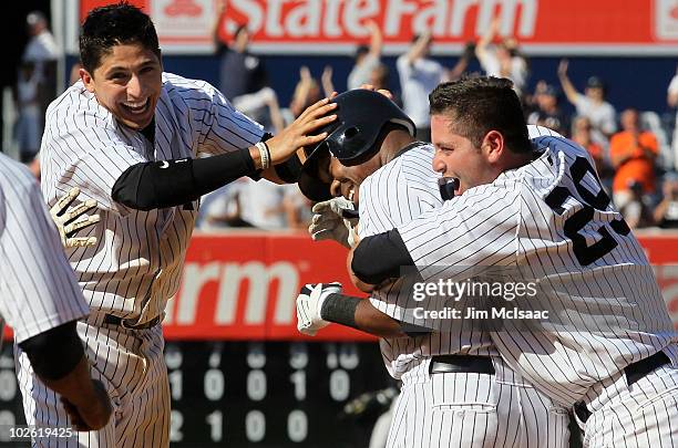 Marcus Thames of the New York Yankees celebrates his hitting a game winning tenth inning RBI single against the Toronto Blue Jays with teammates...