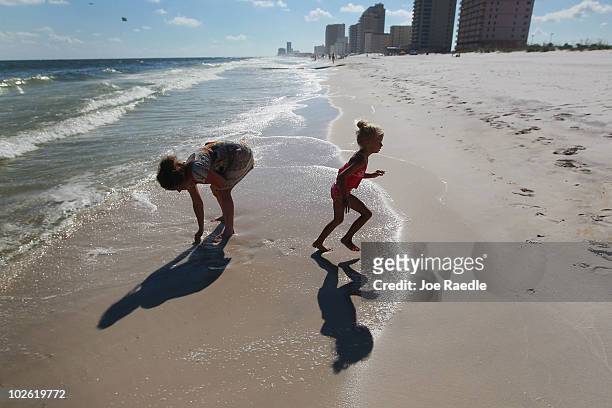 Summer Miller and her mother Tammy James walk along a beach which was not as busy as last year as people stayed away due to the threat of...