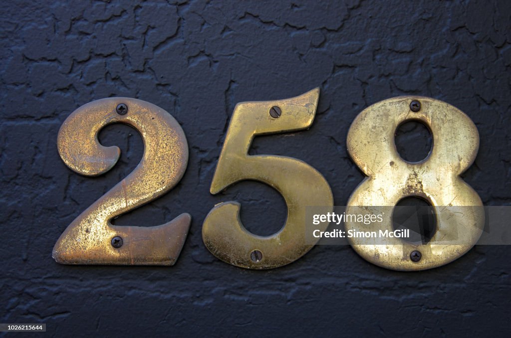 Number 258 In Brass Numerals On A Stucco Wall Painted Dark Grey High ...