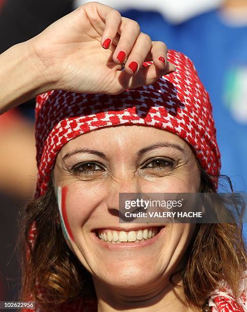 Supporter of Italy's football team with her face painted with a flag poses ahead of the Group F first round 2010 World Cup football match between...