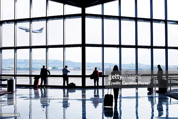 silhouettes of passengers waiting at an airport - aeroporto foto e immagini stock