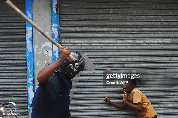 A Bangladeshi policeman threatens a chil A Bangladeshi policeman threatens a chil
