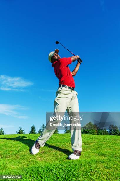 golfer on course swinging club to hit the ball - man swinging golf club stock pictures, royalty-free photos & images