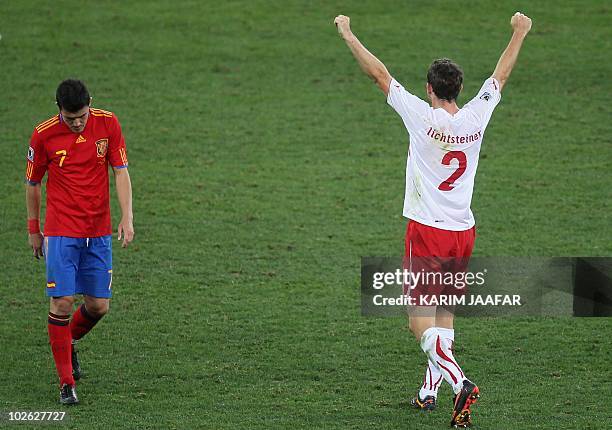 Switzerland's defender Stephan Lichtsteiner celebrates as Spain's striker David Villa looks down at the pitch after the Group H first round 2010...