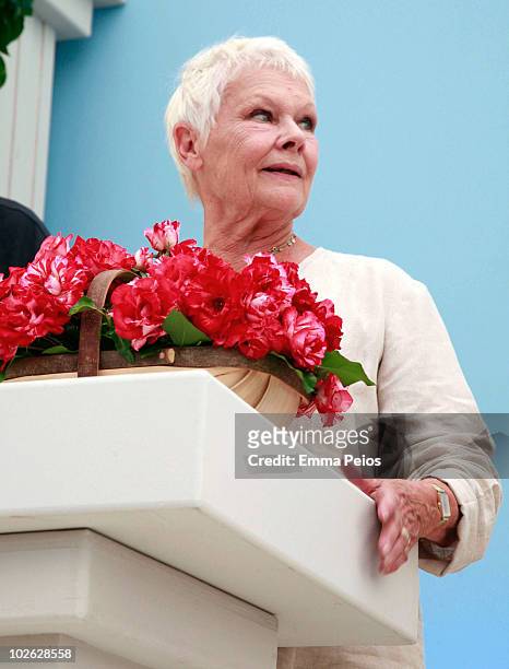 Dame Judi Dench poses with a trug of 'Drama Queen' roses while attending the press preview at the Hampton Court Palace Flower Show at Hampton Court...