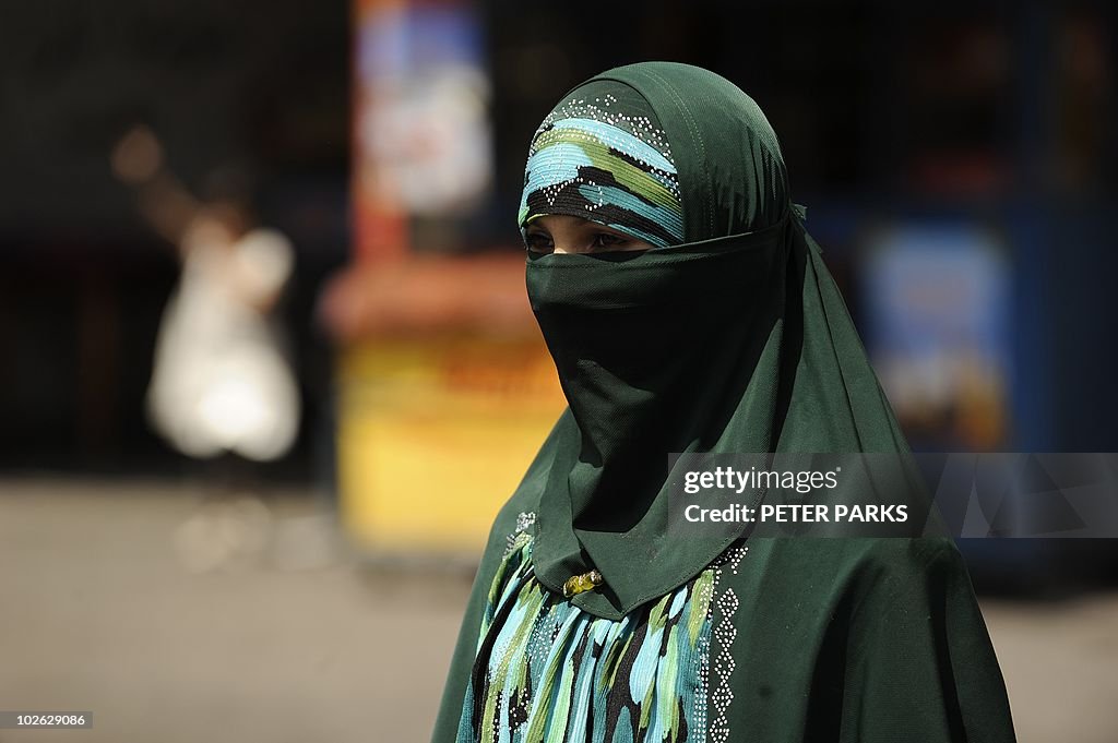 A Muslim ethnic Uighur woman walks on a