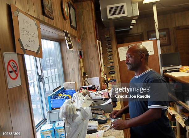 Brian Harvey works the cash register at Beshel Boat Launch on July 5, 2010 in East Pointe a La Hache, Louisiana. Harvey is concerned that as...