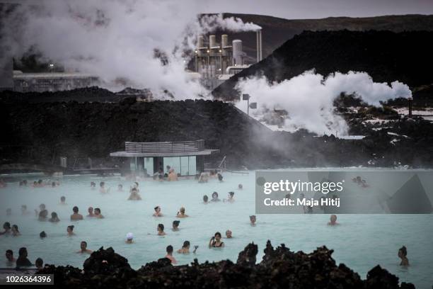 Visitors sit in the geothermal waters at the Blue Lagoon close to the Icelandic capital of Reykjavik on August 30, 2018 in Reykjavik, Iceland.