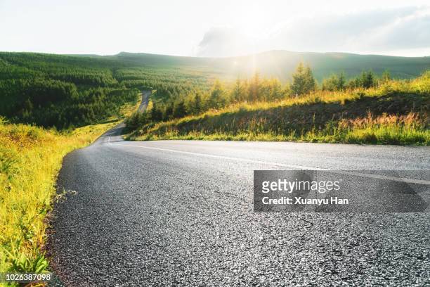 shot of a long open road stretching out far away into the distance - long road stockfoto's en -beelden