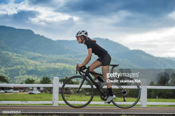 asian female cyclist cycling on track - faster horses stock pictures, royalty-free photos & images