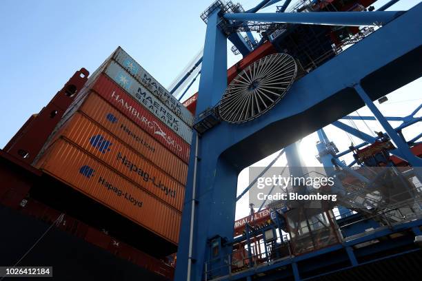 Shipping containers stand beneath ship-to-shore cranes during cargo unloading and loading operations at the HLA Container Terminal Altenwerder in the...