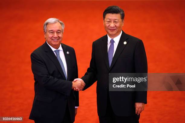 United Nations Secretary-General Antonio Guterres, left, shakes hands with Chinese President Xi Jinping as they pose for photographers during the...