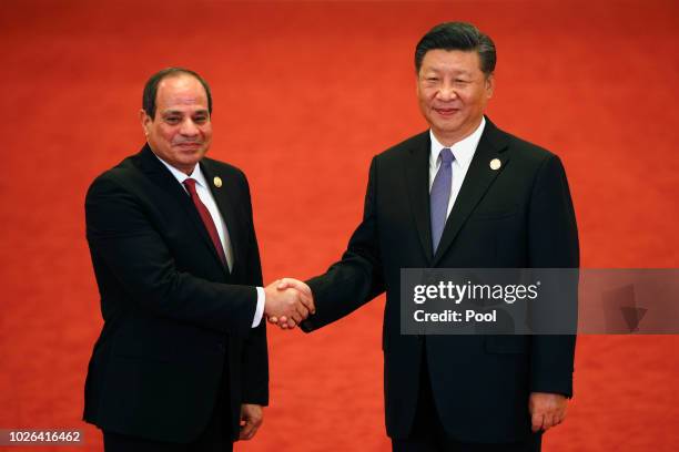 Egypt's President Abdel Fattah al-Sisi, left, shakes hands with Chinese President Xi Jinping as they pose for photographers during the Forum on...