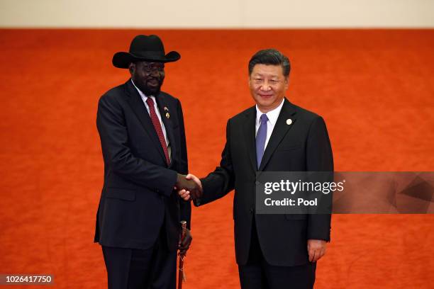 South Sudan President Salva Kiir Mayardit, left, shakes hands with Chinese President Xi Jinping as they pose for photograph during the Forum on...