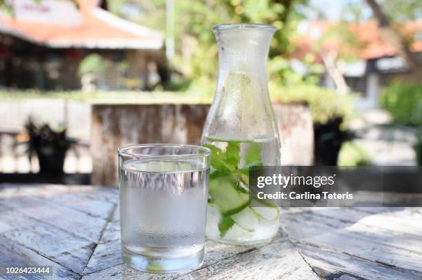 water jug and glass on a wooden outdoor table - carafe stock pictures, royalty-free photos & images