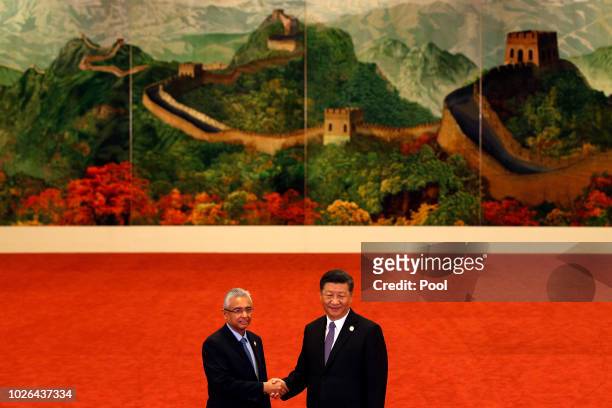 Mauritius Prime Minister Pravind Kumar Jugnauth, left, shakes hands with Chinese President Xi Jinping during the Forum on China-Africa Cooperation...