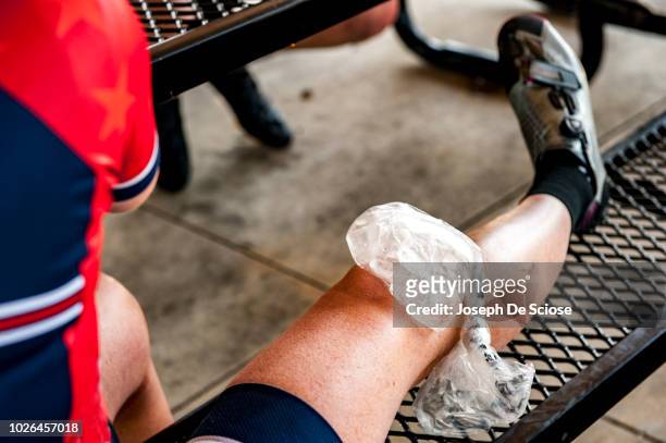ice pack on woman's knee - compresse stock-fotos und bilder