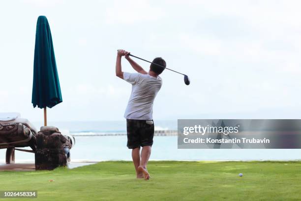 man playing golf - young men golfing stock pictures, royalty-free photos & images