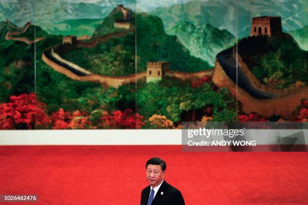 China's President Xi Jinping stands in front of a painting of the Great Wall of China as he arrives for a welcome ceremony for the Forum on...