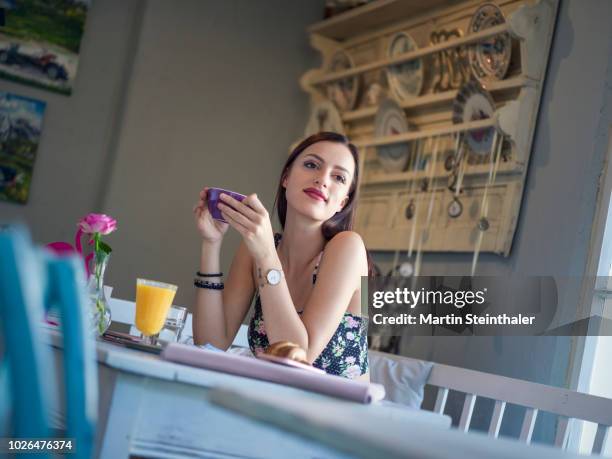 frau sitzt im café bei frühstück mit kaffee in der hand - business frau mit ipad stockfoto's en -beelden