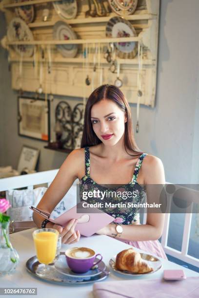 frau sitzt im café bei frühstück und arbeitet mit tablet - frau essen stock pictures, royalty-free photos & images