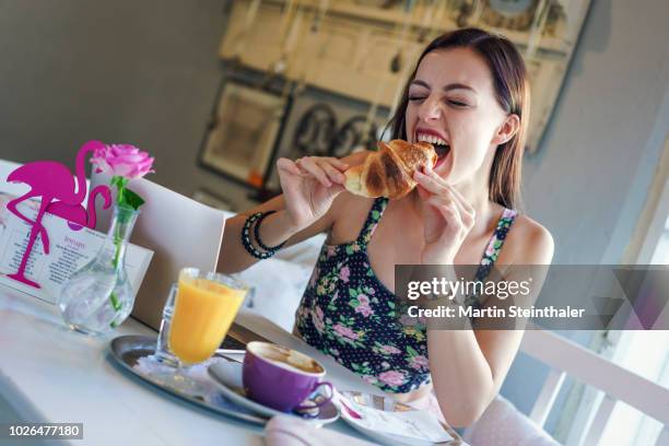 frau isst und genießt genüsslich ein croissant - frau essen stock pictures, royalty-free photos & images