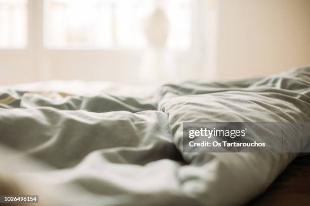 detalle de cama deshecha - bedsheets stockfoto's en -beelden