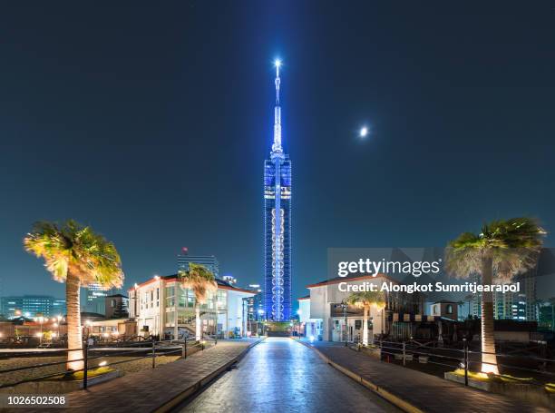 beautiful night view cityscape of the fukuoka tower with light and moon, a tall skyscraper building located in the momochihama area of fukuoka, japan. - fukuoka prefecture stock pictures, royalty-free photos & images