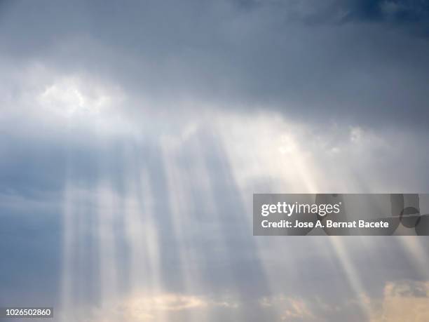 full frame of the low angle view of white and gray clouds of rain and storm with sunbeams. valencian community, spain - sonne himmel stock-fotos und bilder