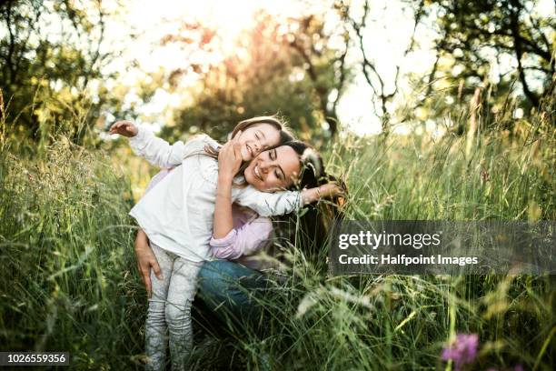 happy mother holding her small daughter outside in spring nature. - child eyes closed stock pictures, royalty-free photos & images