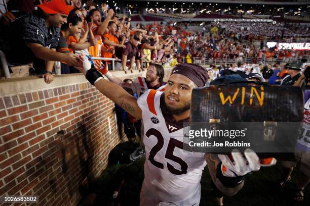 Ricky Walker of the Virginia Tech Hokies wearing the ceremonial jersey No. 25 celebrates with fans after the game against the Florida State Seminoles...