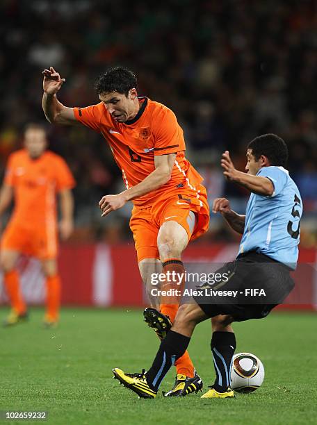 Mark Van Bommel of the Netherlands in action against Walter Gargano of Uruguay during the 2010 FIFA World Cup South Africa Semi Final match between...