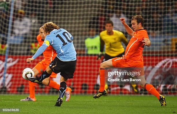 Diego Forlan of Uruguay shoots a long range effort and scores his team's first goal during the 2010 FIFA World Cup South Africa Semi Final match...