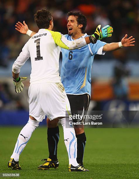 Fernando Muslera of Uruguay celebrates his team's first goal with Mauricio Victorino during the 2010 FIFA World Cup South Africa Semi Final match...