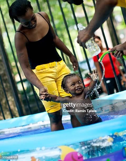 The Richardson family of Brooklyn play in an inflatable pool near their apartment on July 6, 2010 in the Brooklyn borough of New York City. The...