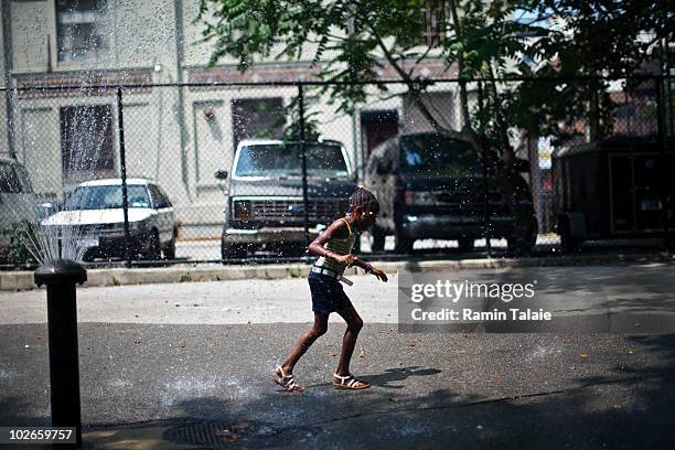 Girl runs through a water fountain to cool off on July 6, 2010 in the Brooklyn borough of New York City. The National Weather Service has issued a...