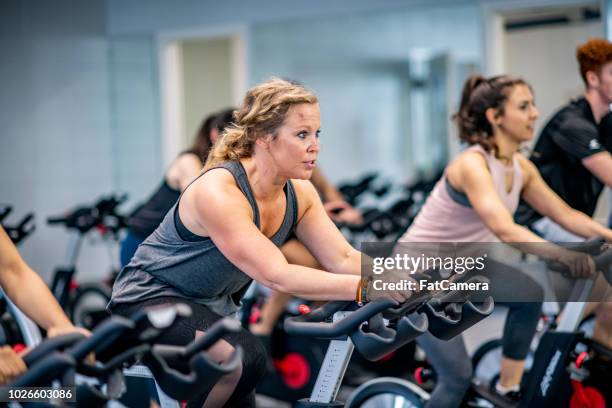 riding exercise bikes - exercise bike class stock pictures, royalty-free photos & images
