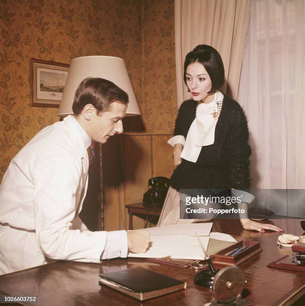 French fashion designer Marc Bohan, new creative director at the house of Dior, pictured with a Dior model whilst at work in an office in Paris in...