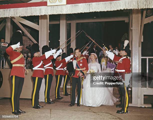 View of Prince Edward, Duke of Kent and his bride Katharine Worsley as they leave York Minster under the raised swords of a military guard of honour...